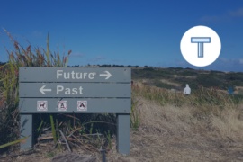 sign on beach with arrows pointing toward future and past