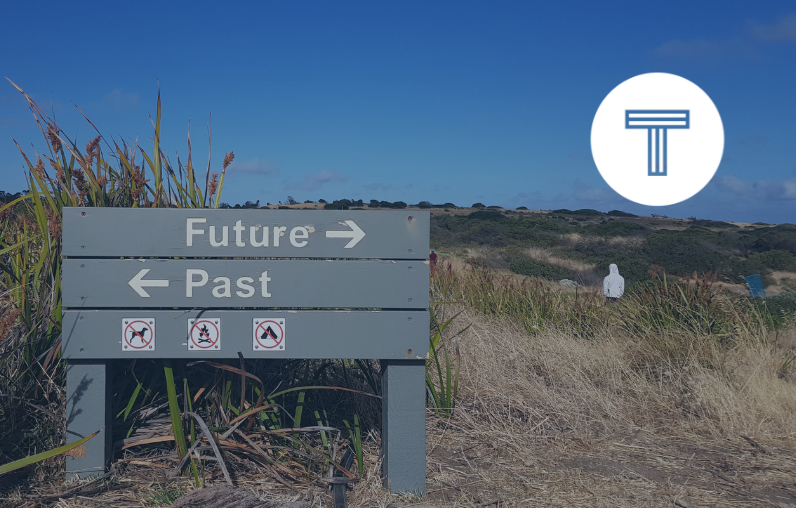 sign on beach with arrows pointing toward future and past