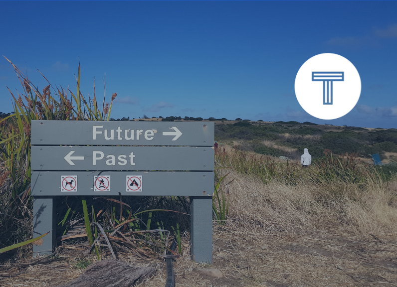 sign on beach with arrows pointing toward future and past