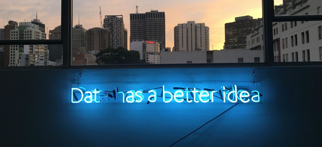 Neon sign that reads data below window overlooking city machine learning