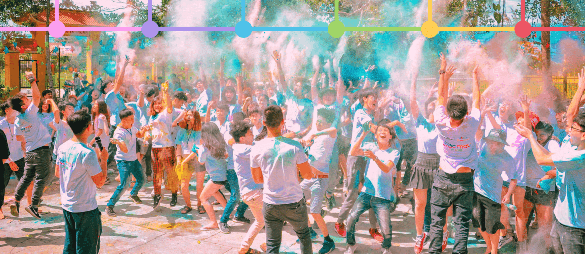 People engaging at holi event with graphical overlay if six colored logos