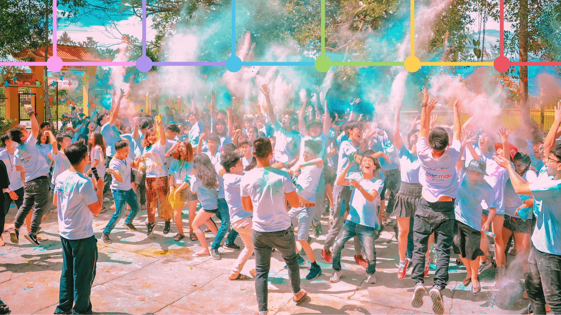 People engaging at holi event with graphical overlay if six colored logos