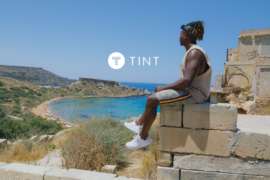 Man sitting on a ledge overlooking the ocean