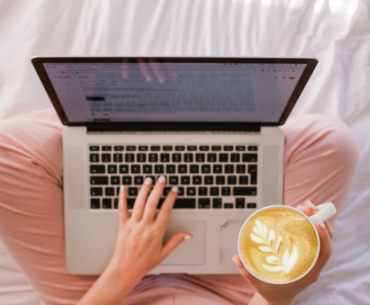 A birds eye views of a woman on her laptop on her bed