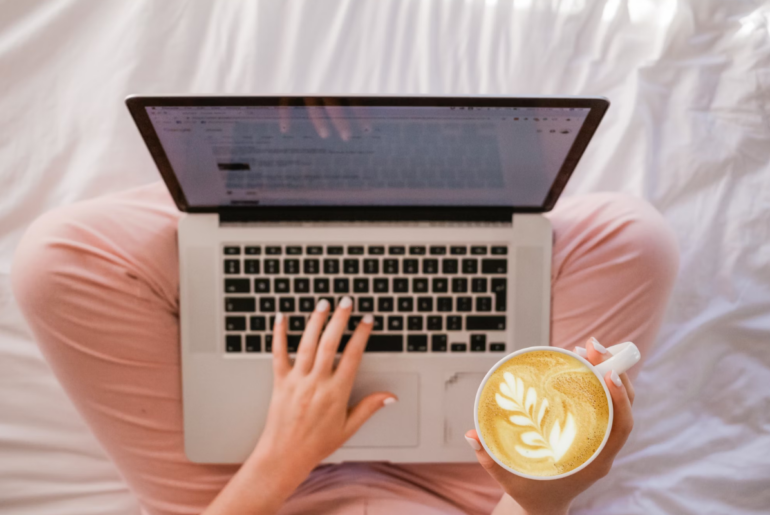 A birds eye views of a woman on her laptop on her bed