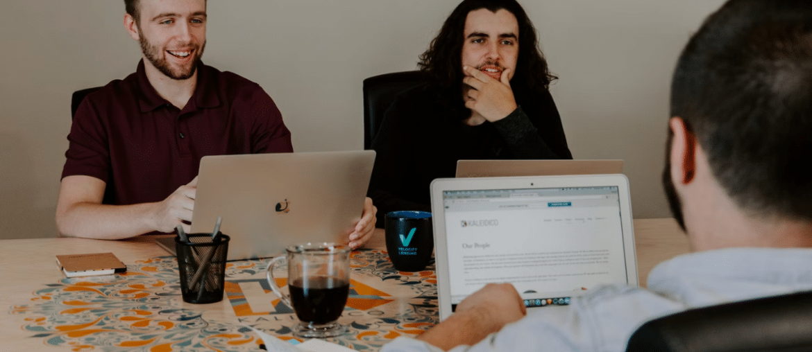 three men on their laptops, collaborating