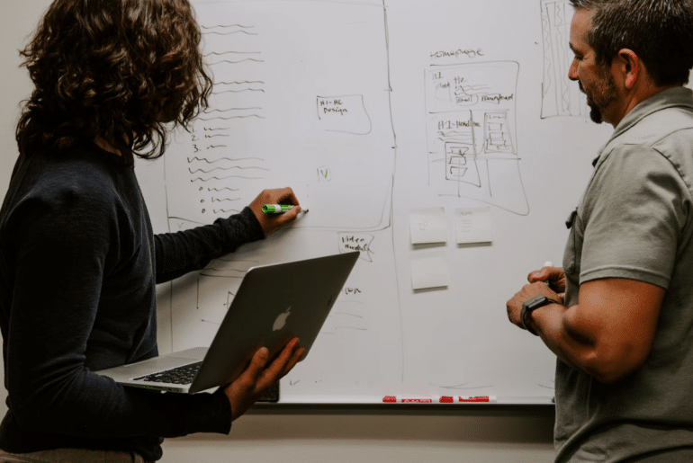 Two people collaborating on a whiteboard