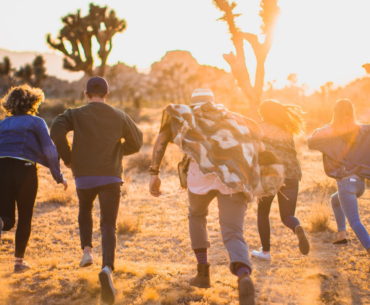 A group of friends running towards the desert