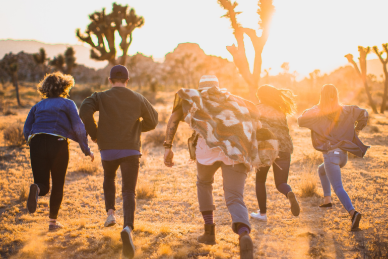 A group of friends running towards the desert