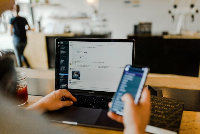 A man on his laptop and cellphone at the same time