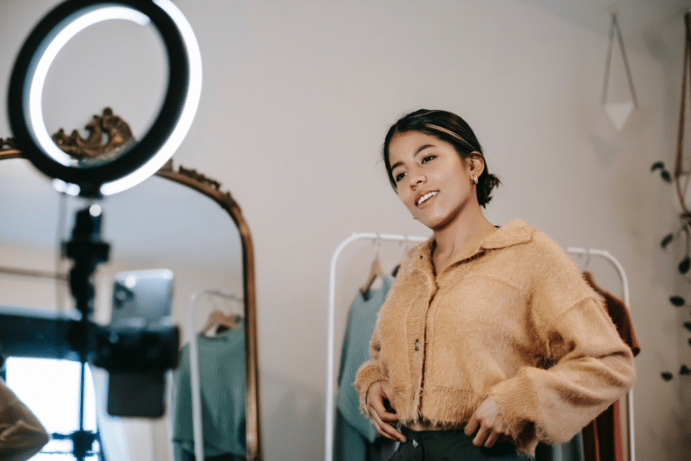 A woman taking a photo as a ring light points at her