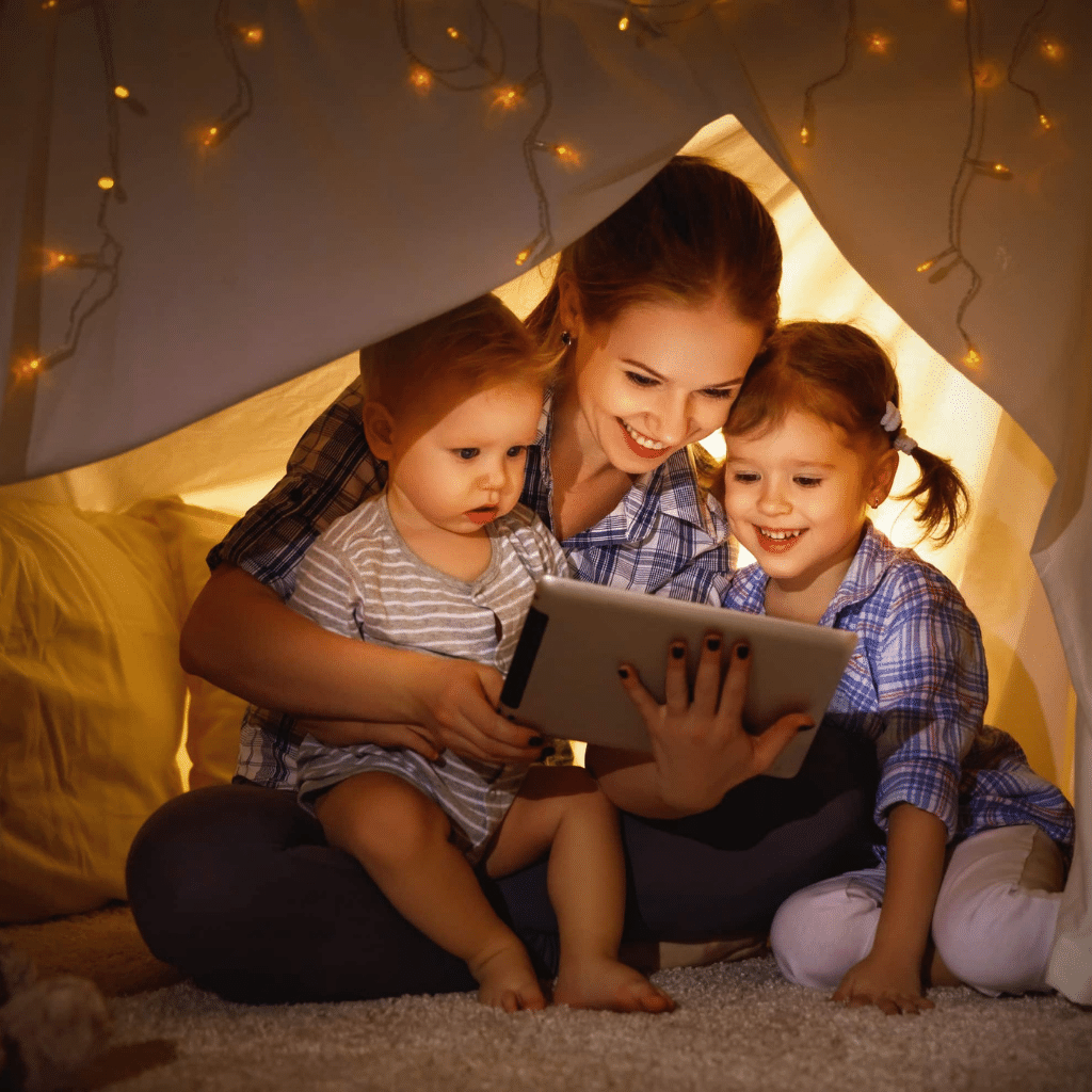 Mother reading in starry tent with children
