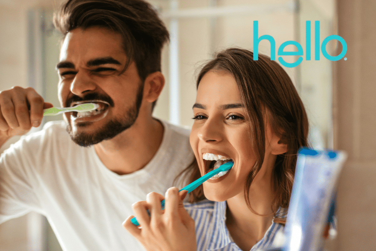Man and woman brushing their teeth alongside the hello logo